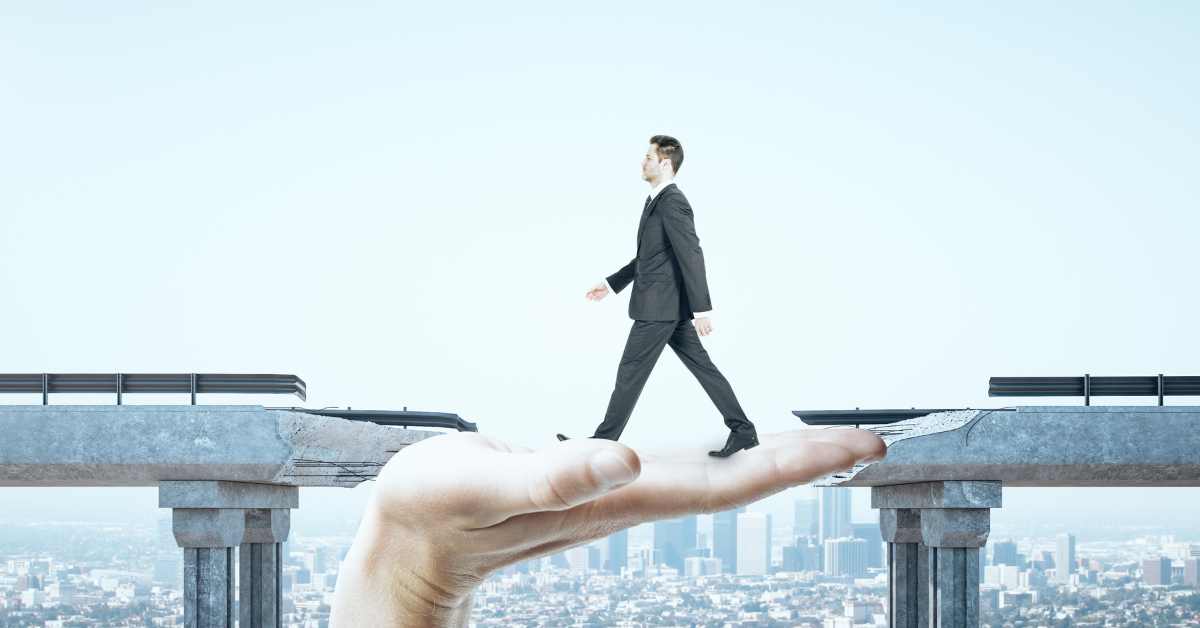 Fintech phone, fintech notebook, and coffee cup on table, with a hand over the notebook with a pen.