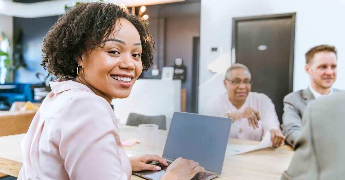 phone, fintech notebook, and coffee cup on table, with a hand over the notebook with a pen.
